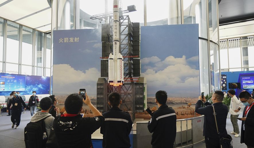 In this photo released by Xinhua News Agency, visitors view a simulated rocket launch on display at an exhibition featuring space science and achievement during the China Space Conference in Nanjing in east China&#39;s Jiangsu province on Saturday, April 24, 2021. China will launch its next robot lunar lander in 2024, and it will carry equipment from France, Sweden, Russia and Italy, the official news agency reported. (Ji Chunpeng/Xinhua via AP)