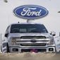 FILE - In this Sunday, Oct. 11, 2020, file photo, a row of 2020 sports-utility vehicles pickup trucks sits at a Ford dealership, in Denver. Ford Motor Co. says it made $3.26 billion in the first quarter, helped by rising vehicle prices and in spite of production cuts due to a global shortage of computer chips. The earnings reversed a nearly $2 billion net loss from a year ago, when Ford burned through cash at the start of the coronavirus pandemic. (AP Photo/David Zalubowski, File)