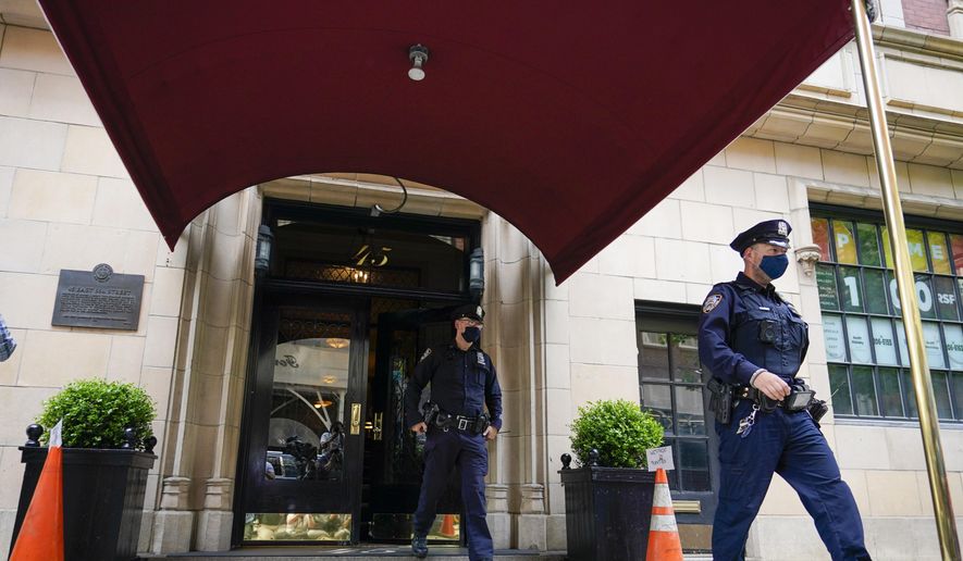 New York City Police officers walk out of the apartment building where former New York Mayor Rudy Giuliani resides, Wednesday, April 28, 2021, in New York. Federal agents on Wednesday raided Giuliani’s Manhattan home and office, seizing computers and cell phones in a major escalation of the Justice Department’s investigation into the business dealings of former President Donald Trump’s personal lawyer. (AP Photo/Mary Altaffer)
