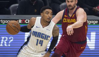 Orlando Magic&#39;s Gary Harris (14) drives past Cleveland Cavaliers&#39; Kevin Love during the first quarter of an NBA basketball game Wednesday, April 28, 2021 in Cleveland. (AP Photo/Phil Long)