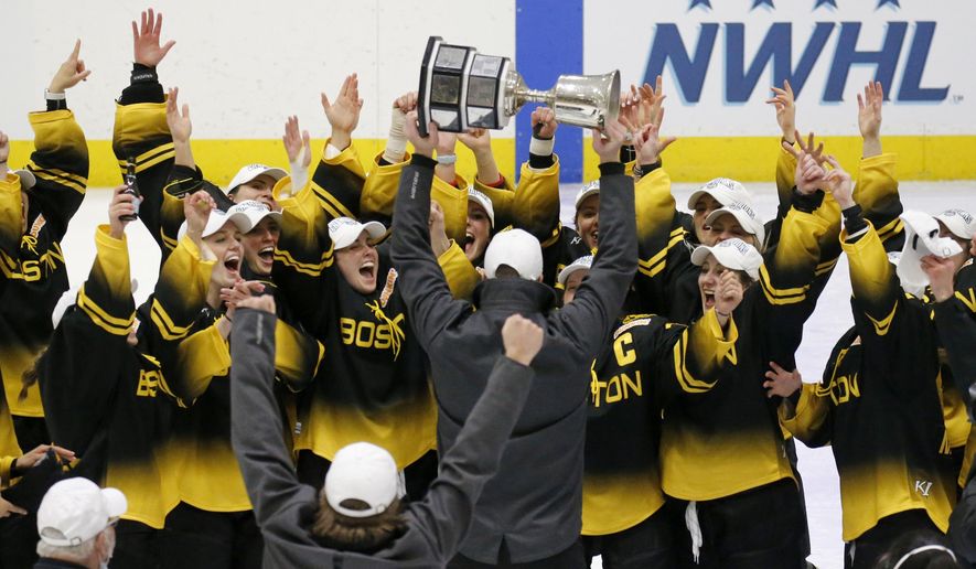 FILE - Boston Pride players cheer as coach Paul Mara hoists the NWHL Isobel Cup trophy after the team's win over the Minnesota Whitecaps in the championship hockey game in Boston, in this Saturday, March 27, 2021, file photo. The National Women’s Hockey League made a potentially game-changing decision for the sport in approving to double its salary cap to $300,000 for each of its six teams on Wednesday, April 28, 2021, based on projections it is making strides in achieving financial stability entering its seventh season. (AP Photo/Mary Schwalm, File)