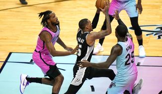 San Antonio Spurs guard Dejounte Murray (5) drives to the basket as Miami Heat forward Trevor Ariza, left, and guard Kendrick Nunn (25) defend during the second half of an NBA basketball game Wednesday, April 28, 2021, in Miami. (AP Photo/Lynne Sladky)