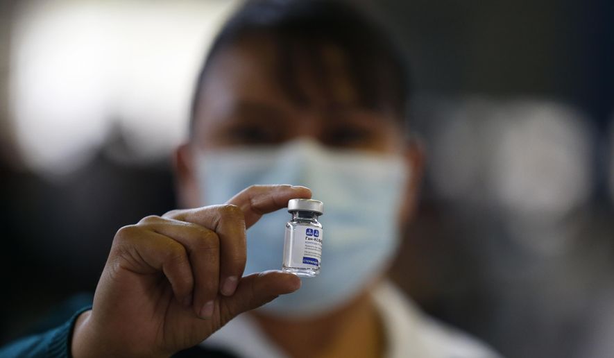 In this Feb. 24, 2021, file photo, a medical worker holds up a vial of the Sputnik V coronavirus vaccine, as the city health department conducts a mass vaccination campaign for Mexicans over age 60, at Palacio de los Deportes in Mexico City. Mexico will begin bottling and packaging the Russian vaccine, Mexico Foreign Affairs Secretary Marcelo Ebrard said Wednesday, April 28, 2021, during a visit to Russia. (AP Photo/Rebecca Blackwell, File)