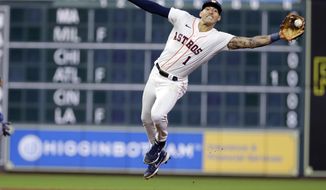 Houston Astros shortstop Carlos Correa reaches for the throw before tagging out Seattle Mariners&#39; Dylan Moore, who was picked off on a steal attempt during the eighth inning of a baseball game Wednesday, April 28, 2021, in Houston. (AP Photo/Michael Wyke)