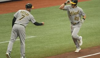 Oakland Athletics third base coach Mark Kotsay (7) congratulates Matt Chapman (26) after his solo home run off Tampa Bay Rays&#39; Shane McClanahan during the fourth inning of a baseball game Thursday, April 29, 2021, in St. Petersburg, Fla. (AP Photo/Steve Nesius)