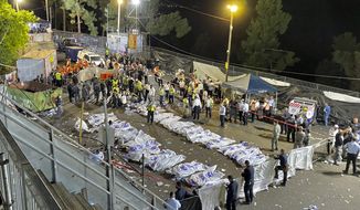 Israeli security officials and rescuers stand around the bodies of victims who died during a Lag Ba&#39;Omer celebrations at Mt. Meron in northern Israel, Friday, April 30, 2021. The director of an Israeli ambulance service has confirmed that nearly 40 people died in a stampede at a religious festival in northern Israel. (Ishay Jerusalemite/Behadrei Haredim via AP)