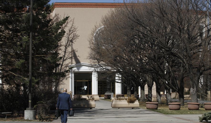 A man walks to work at the state capitol building on Tuesday, March 30, 2021, in Santa Fe, New Mexico. Legislators met in a special session to revisit a sprawling set of marijuana legalization proposals that led to a deadlock during the regular session earlier in March.(AP Photo/Cedar Attanasio)