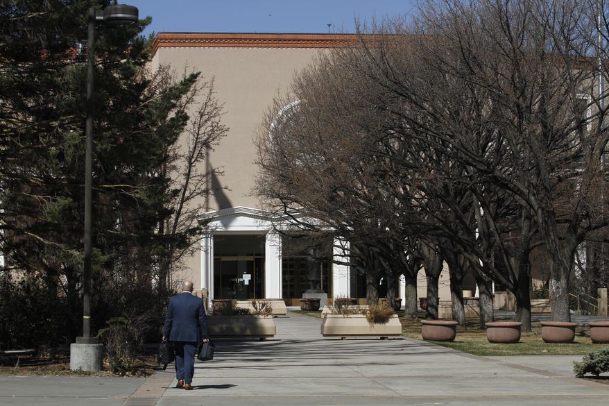 A man walks to work at the state capitol building on Tuesday, March 30, 2021, in Santa Fe, New Mexico. Legislators met in a special session to revisit a sprawling set of marijuana legalization proposals that led to a deadlock during the regular session earlier in March.(AP Photo/Cedar Attanasio)