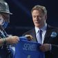 A Detroit Lions fan, left, who was chosen to be on stage, holds a team jersey with the name of the team&#39;s first-round pick Penei Sewell, an offensive lineman from Oregon, at the NFL football draft Thursday April 29, 2021, in Cleveland. (AP Photo/Tony Dejak)