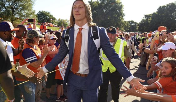 FILE - In this Aug. 29, 2019, file photo, Clemson&#39;s Trevor Lawrence greets fans as he arrives for the team&#39;s NCAA college football game against Georgia Tech in Clemson, S.C. Trevor Lawrence and Zach Wilson are expected to be the top two picks selected in the NFL Draft on Thursday, April 29, 20212, in Cleveland. (AP Photo/Richard Shiro, File)