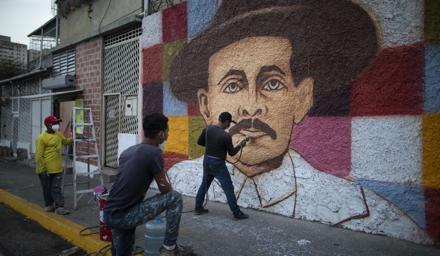 Venezuelan artist Miguel Garcia puts on the finishing touches on his mural of Venezuelan popular saint, Dr. Jose Gregorio Hernandez, in Caracas, Venezuela, Monday, April 26, 2021. Known as the doctor of the poor, Hernandez is set to be beatified by the Catholic church, a step towards sainthood, on April 30th. (AP Photo/Ariana Cubillos)