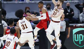 Washington Wizards&#39; Russell Westbrook (4) looks to pass between Cleveland Cavaliers&#39; Dean Wade (32) and Jarrett Allen (31) during the first half of an NBA basketball game, Friday, April 30, 2021, in Cleveland. (AP Photo/Ron Schwane)