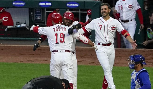 Cincinnati Reds&#x27; Joey Votto (19) is congratulated by Nick Castellanos (2) at home plate after hitting a two-run home run, his 300th career home run, in the third inning of a baseball game against the Chicago Cubs at Great American Ball Park in Cincinnati on Friday, April 30, 2021. (AP Photo/Jeff Dean)