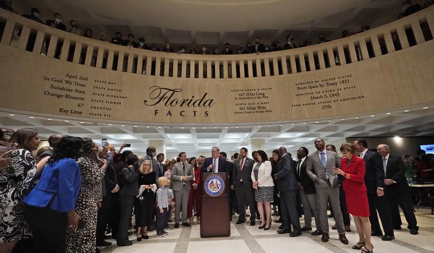 Surrounded by lawmakers, Florida Senate President Wilton Simpson speaks to members of the media after the end of a legislative session, Friday, April 30, 2021, at the Capitol in Tallahassee, Fla. (AP Photo/Wilfredo Lee)
