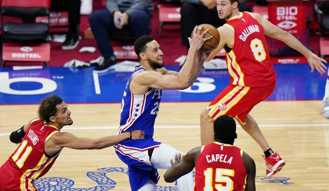 Philadelphia 76ers&#x27; Ben Simmons (25) goes up for a shot as Atlanta Hawks&#x27; Trae Young (11) hangs on during the second half of an NBA basketball game, Friday, April 30, 2021, in Philadelphia. (AP Photo/Matt Slocum)