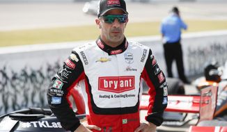 FILE - In this July 17, 2020, file photo, driver Tony Kanaan, of Brazil, stands next to his car during qualifying for an IndyCar Series auto race at Iowa Speedway in Newton, Iowa. Kanaan’s supposed farewell tour last year fizzled amid nearly empty tracks. Then he was given another chance to extend his IndyCar career, this time before fans. His first two races come this weekend at Texas Motor Speedway. (AP Photo/Charlie Neibergall, File)