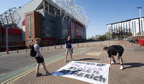 FILE - In this Monday, April 19, 2021 file photo, supporters place a protest banner outside Manchester United&#39;s Old Trafford Stadium, Manchester, England, opposing the formation of the European Super League. Manchester United tried to reassure skeptical fans that it won&#39;t revive plans for the Super League, though many supporters still expressed outrage on Friday April 30, 2021. (AP Photo/Jon Super, File)
