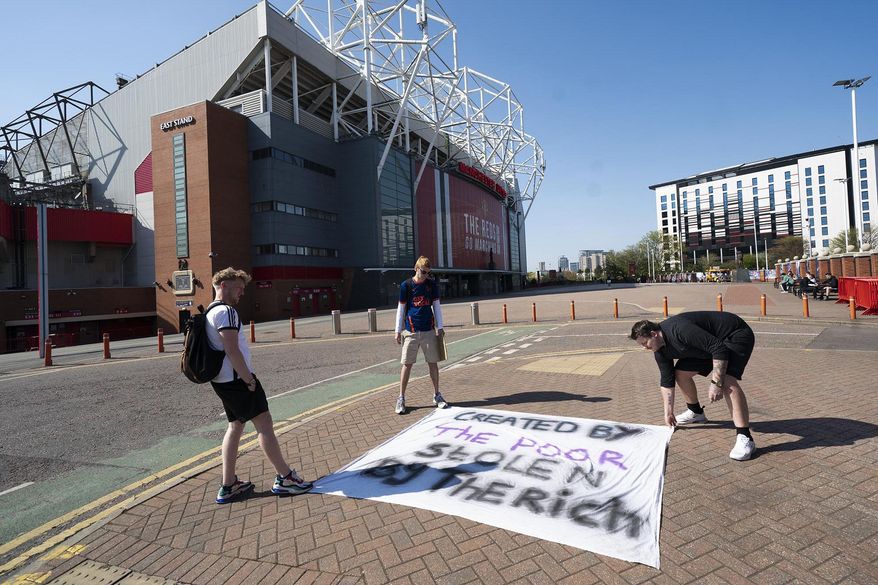 FILE - In this Monday, April 19, 2021 file photo, supporters place a protest banner outside Manchester United&#x27;s Old Trafford Stadium, Manchester, England, opposing the formation of the European Super League. Manchester United tried to reassure skeptical fans that it won&#x27;t revive plans for the Super League, though many supporters still expressed outrage on Friday April 30, 2021. (AP Photo/Jon Super, File)