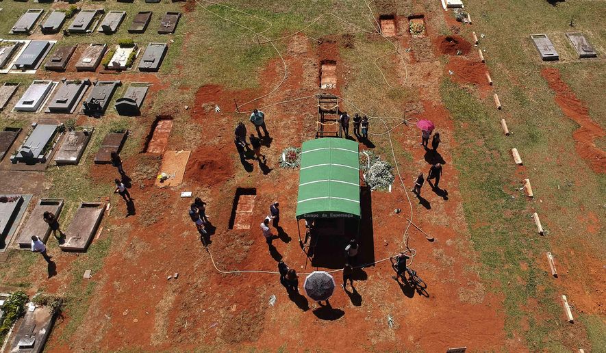 A family attends the burial service for David Ferreira Gomes, who died from complications related to COVID-19, at the Campo da Esperanca cemetery in Brasilia, Brazil, Friday, April 16, 2021. Brazil marked a milestone of 400,000 COVID-19 deaths Thursday, April 29, 2021, the world&#39;s second-highest tally, with the majority recorded in just the last four months. (AP Photo/Eraldo Peres)