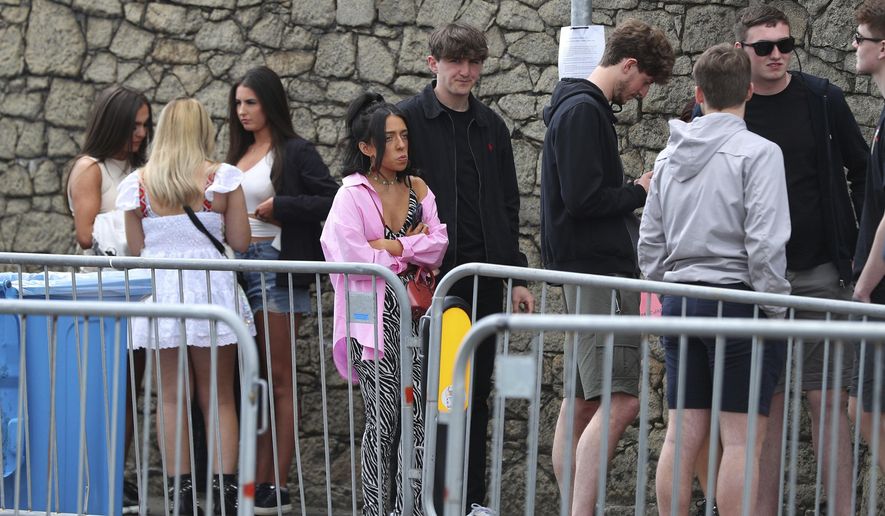 People arrive at Circus nightclub in Liverpool, England, Friday April 30, 2021, for a COVID-19 safety pilot event. Researchers at the event will gather evidence for the national Events Research programme (ERP) which will see 6,000 clubbers across two nights take over Bramley Moore Dock warehouse in an event which requires no social distancing or face coverings. (Peter Byrne/PA via AP)