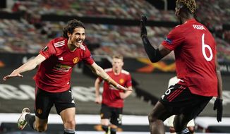 Manchester United&#39;s Edinson Cavani, left, celebrates after scoring his side&#39;s third goal during the Europa League semi final, first leg soccer match between Manchester United and Roma at Old Trafford in Manchester, England, Thursday, April 29, 2021. (AP Photo/Jon Super)