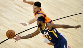 Phoenix Suns guard Devin Booker and Utah Jazz forward Royce O&#x27;Neale (23) battle for the ball during the first half of an NBA basketball game, Friday, April 30, 2021, in Phoenix. (AP Photo/Matt York)