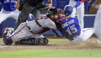 Atlanta Braves catcher Travis d&#39;Arnaud tags out Toronto Blue Jays&#39; Randal Grichuk during the sixth inning of a baseball game Saturday, May 1, 2021, in Dunedin, Fla. (AP Photo/Mike Carlson)