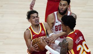 Atlanta Hawks guard Trae Young, left, and John Collins (20) battle Chicago Bulls guard Denzel Valentine (45) in the second half of an NBA basketball game Saturday, May 1, 2021, in Atlanta. (AP Photo/John Bazemore)