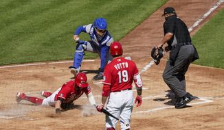 Cincinnati Reds&#39; Tyler Naquin, left, scores a run after teammate Nick Castellanos (not shown) hit a double in the first inning during a baseball game against the Chicago Cubs in Cincinnati on Saturday, May 1, 2021. (AP Photo/Jeff Dean)