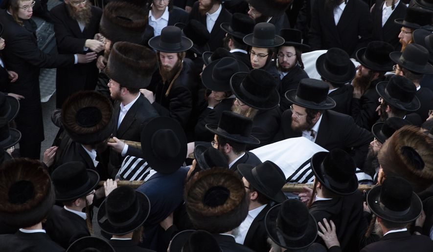 Ultra-Orthodox men carry the bodies of Moshe Englard, 14, and his brother, Joshua, 12, who died during Lag BaOmer celebrations at Mt. Meron in northern Israel, in Jerusalem on Friday, April 30, 2021. A stampede at the religious festival attended by tens of thousands of ultra-Orthodox Jews in northern Israel killed dozens of people and injured about 150 early Friday, medical officials said. It was one of the country's deadliest civilian disasters. (AP Photo/Ariel Schalit)