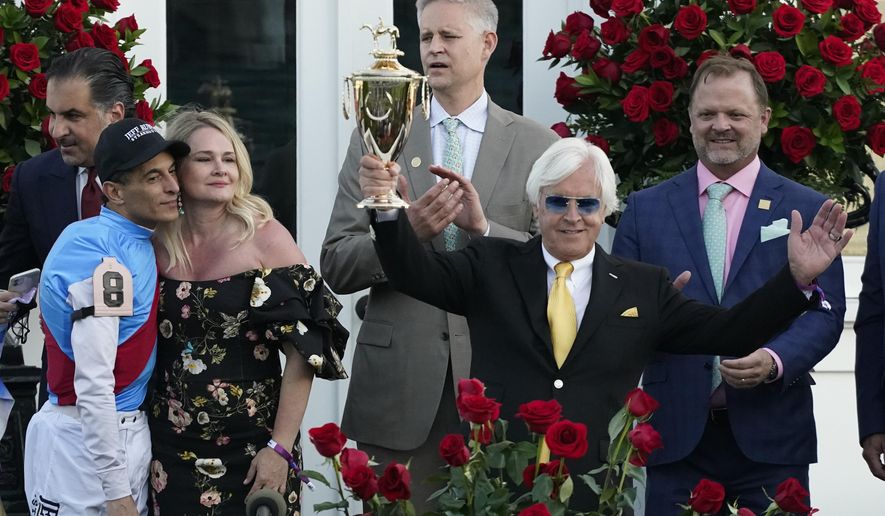 Jockey John Velazquez, left, watches as trainer Bob Baffert holds up the winner&#39;s trophy after they victory with Medina Spirit in the 147th running of the Kentucky Derby at Churchill Downs, Saturday, May 1, 2021, in Louisville, Ky. (AP Photo/Jeff Roberson) ** FILE **