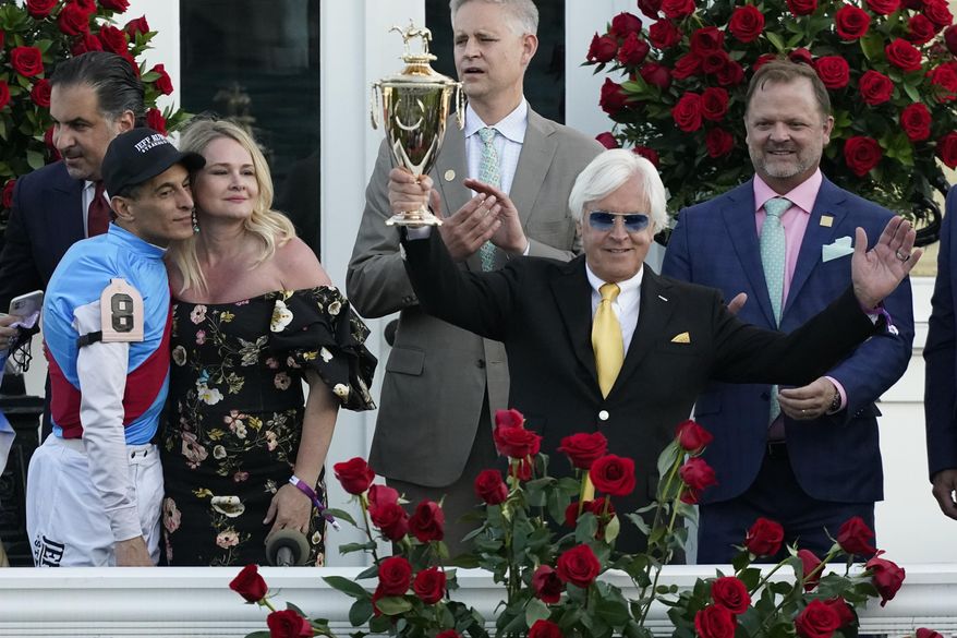 Jockey John Velazquez, left, watches as trainer Bob Baffert holds up the winner&#39;s trophy after they victory with Medina Spirit in the 147th running of the Kentucky Derby at Churchill Downs, Saturday, May 1, 2021, in Louisville, Ky. (AP Photo/Jeff Roberson) ** FILE **