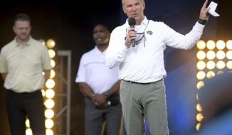 Jacksonville Jaguars coach Urban Meyer addresses the crowd, backed by offensive coordinator Darrell Bevell and assistant head coach Charlie Strong, during an NFL football draft party Thursday, April 29, 2021, in Jacksonville, Fla. (Bob Self/The Florida Times-Union via AP)