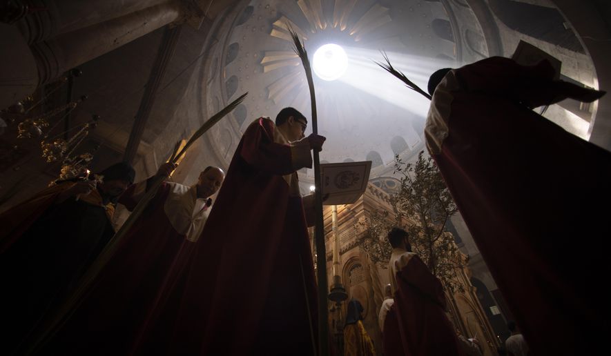 Priests hold palm fronds during the Palm Sunday procession at the Church of the Holy Sepulchre, where many Christians believe Jesus was crucified, buried and rose from the dead, in the Old City of Jerusalem, Sunday, April. 25, 2021. Followers of the Orthodox and Eastern Churches began marking Holy Week Sunday. (AP Photo/Oded Balilty)