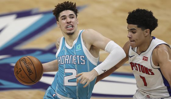 Charlotte Hornets guard LaMelo Ball, left, drives against Detroit Pistons guard Killian Hayes in the second half of an NBA basketball game in Charlotte, N.C., Saturday, May 1, 2021.  (AP Photo/Nell Redmond)