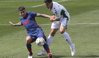 Atletico Madrid&#39;s Angel Correa, left vies for the ball against Elche&#39;s Diego Gonzalez during the Spanish La Liga soccer match between Valencia and Atletico Madrid at the Mestalla stadium in Valencia, Spain, Saturday, May 1, 2021. (AP Photo/Alberto Saiz)