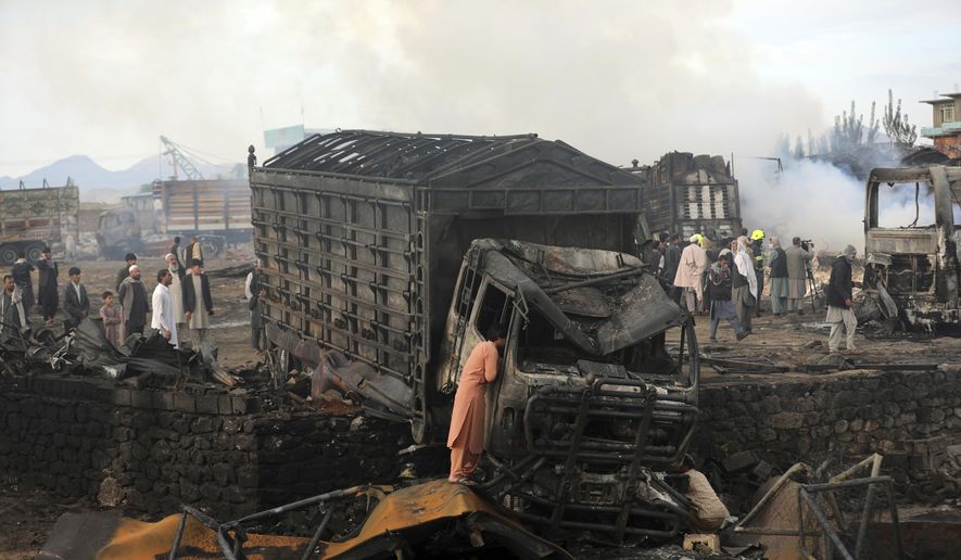 A driver views the damage of his truck caught in a fire in Kabul, Afghanistan, Sunday, May 2, 2021. A fire roared through several fuel tankers on the northern edge of the Afghan capital late Saturday, injuring at least 10 people and plunging much of the city into darkness, officials said. (AP Photo/Rahmat Gul)