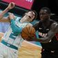 Miami Heat guard Kendrick Nunn, right, pulls a pass away from Charlotte Hornets guard LaMelo Ball during the first half of an NBA basketball game on Sunday, May 2, 2021, in Charlotte, N.C. (AP Photo/Chris Carlson)