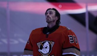 Anaheim Ducks goaltender Ryan Miller listens to the national anthem before the team&#39;s NHL hockey game against the Los Angeles Kings, Saturday, May 1, 2021, in Anaheim, Calif. Miller will retire at the conclusion of the season, ending the 18-year career of the winningest American-born goaltender in NHL history. (AP Photo/Jae C. Hong)