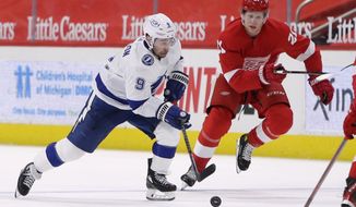 Tampa Bay Lightning center Tyler Johnson (9) is pursued up the ice by Detroit Red Wings defenseman Dennis Cholowski (21) during the first period of an NHL hockey game Sunday, May 2, 2021, in Detroit. (AP Photo/Duane Burleson)