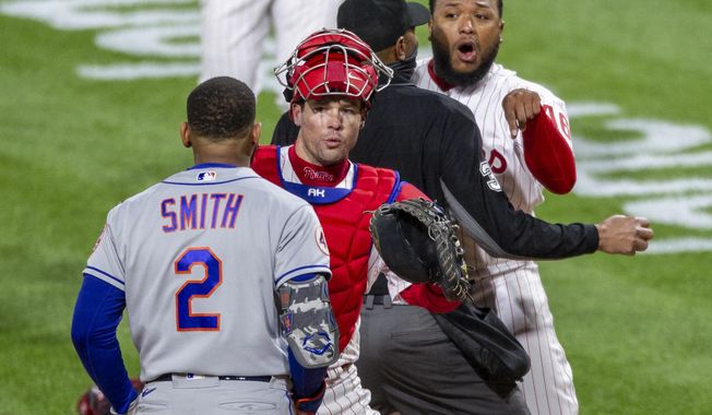 Philadelphia Phillies relief pitcher Jose Alvarado, right, has an altercation with New York Mets&#x27; Dominic Smith (2) as catcher Andrew Knapp tries to intervene after Smith struck out swinging in the eighth inning of a baseball game, Friday, April 30, 2021, in Philadelphia. (AP Photo/Laurence Kesterson)