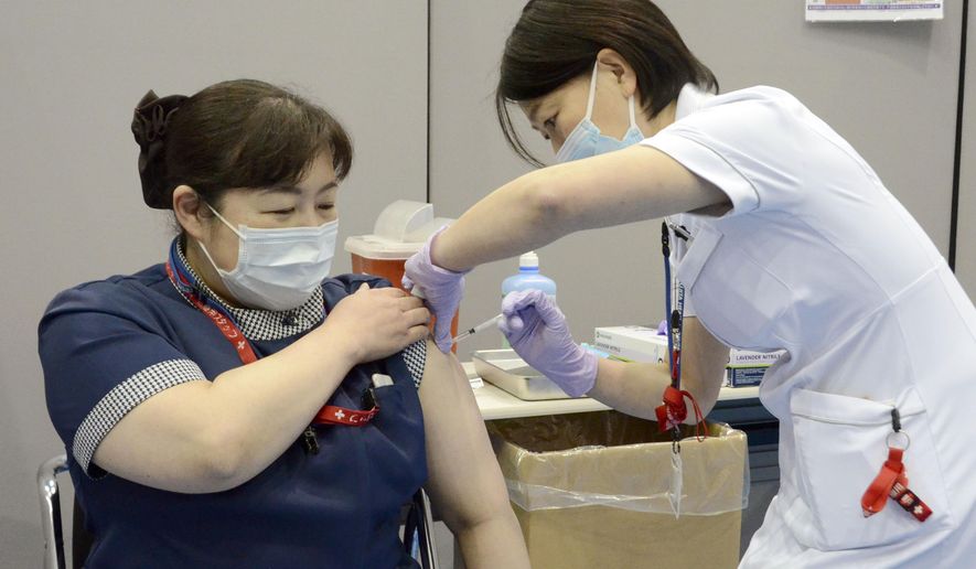 A nurse receives the first dose of the Pfizer COVID-19 vaccine at Fujita Health University Hospital in Toyoake, Aichi prefecture, central Japan, on March 8, 2021. Some nurses in Japan are incensed at a request from Tokyo Olympic organizers to have 500 of them dispatched to help out with the games. They say they’re already near the breaking point dealing with the coronavirus pandemic.  (Kyodo News via AP)