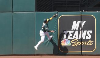 Oakland Athletics center fielder Ramon Laureano catches a fly ball during the eighth inning of a baseball game in Oakland, Calif., Sunday, May 2, 2021. (AP Photo/Jeff Chiu)