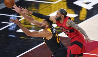 Toronto Raptors guard DeAndre&#39; Bembry, right, and Utah Jazz center Rudy Gobert (27) reach for the ball during the second half of an NBA basketball game Saturday, May 1, 2021, in Salt Lake City. (AP Photo/Rick Bowmer)