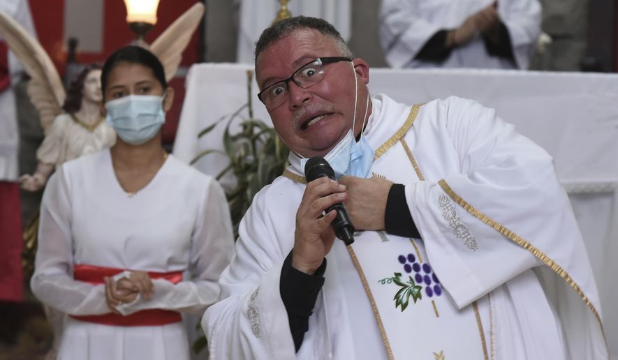 Sergio Valverde Espinoza, a Catholic priest of the Cristo Rey church who modified a popular song called "Sopa de Caracol," or Snail Soup in English, gestures during a Mass in San Jose, Costa Rica, Sunday, May 2, 2021. Valverde changed the song's lyrics to a message calling for the use of face masks and care during the pandemic. (AP Photo/Carlos Gonzalez)