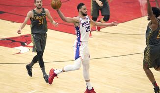 Philadelphia 76ers&#39; Ben Simmons (25) saves the ball from going out of bounds with a long pass as Chicago Bulls&#39; Tomas Satoransky (31) and Thaddeus Young watch during the second half of an NBA basketball game Monday, May 3, 2021, in Chicago. (AP Photo/Charles Rex Arbogast)