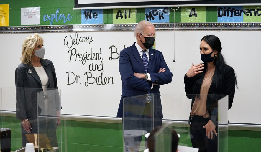 President Joe Biden talks with fifth-grade teacher Cindy Bertamini during a visit to Yorktown Elementary School, Monday, May 3, 2021, in Yorktown, Va., as first lady Jill Biden, looks on. (AP Photo/Evan Vucci)
