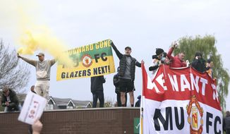 Fans hold up banners as they protest against the Glazer family, owners of Manchester United, before their Premier League match against Liverpool at Old Trafford, Manchester, England, Sunday, May 2, 2021. (Barrington Coombs/PA via AP)