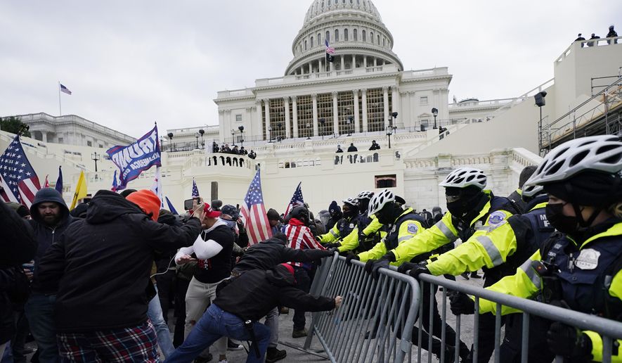 In this Jan. 6, 2021 file photo, Trump supporters try to break through a police barrier at the Capitol in Washington. With riot cases flooding into Washington’s federal court, the Justice Department is under pressure to quickly resolve the least serious cases. (AP Photo/Julio Cortez, File)  **FILE**