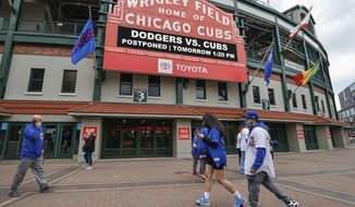 CORRECTS YEAR TO 2021 NOT 2020 - Fans walk outside Wrigley Field as a baseball game between the Chicago Cubs and the Los Angels Dodgers was postponed due to the forecast of inclement weather, Monday, May 3, 2021, in Chicago. (AP Photo/Kamil Krzaczynski)